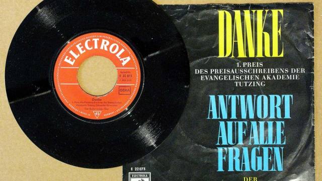 Eine schwarze Schallplatte liegt neben ihrer Hülle mit der Aufschrift „Danke – Antwort auf alle Fragen“. Auf dem Plattenlabel steht „Electrola“ in roter Schrift. Die Gestaltung wirkt retro und erinnert an eine Veröffentlichung aus der Mitte des 20. Jahrhunderts.