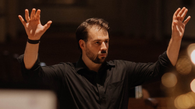 Matthias Fitting Mann mit schwarzem Hemd beim dirigieren